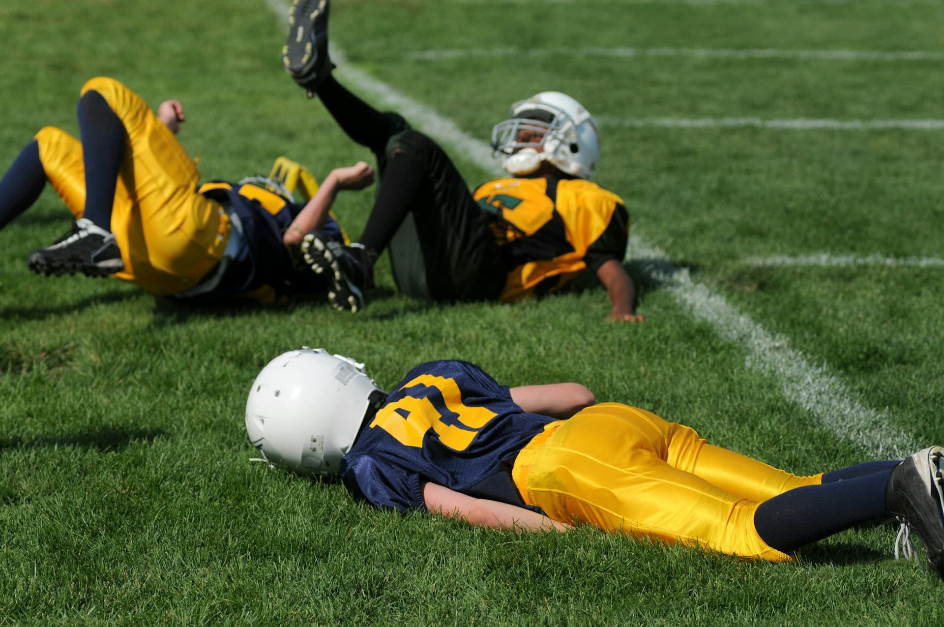 Football players laying on the ground after a play.